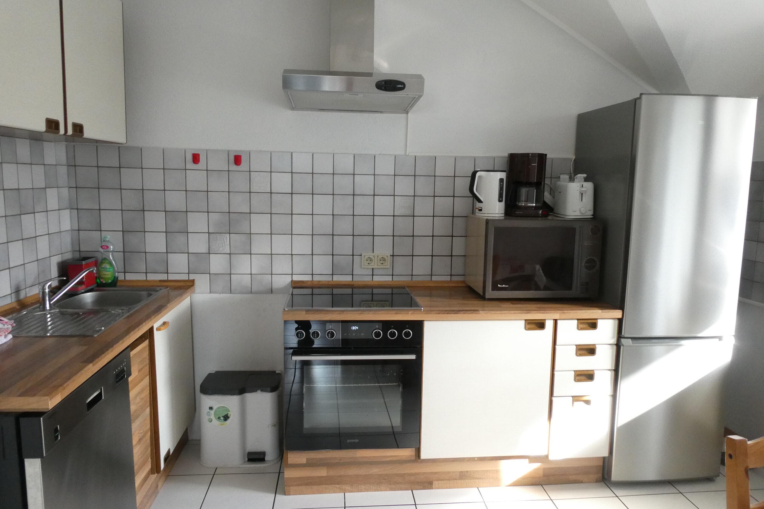 Voll ausgestattete Küche mit Herd, Ofen und Kühlschrank